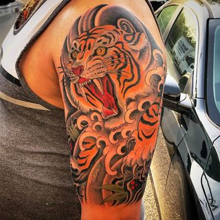 a man with a tiger tattoo on his arm